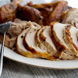 A close up of carved roasted turkey on a plate.