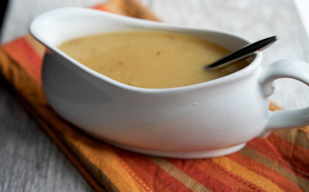 Turkey gravy in a gravy boat with a spoon. 