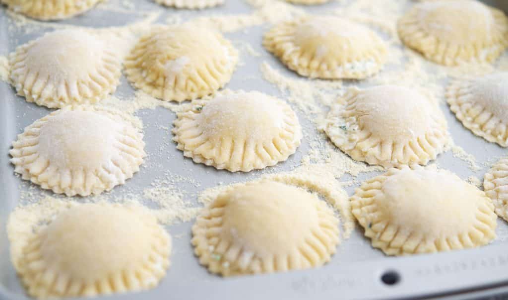 Homemade Ravioli uncooked on a tray.