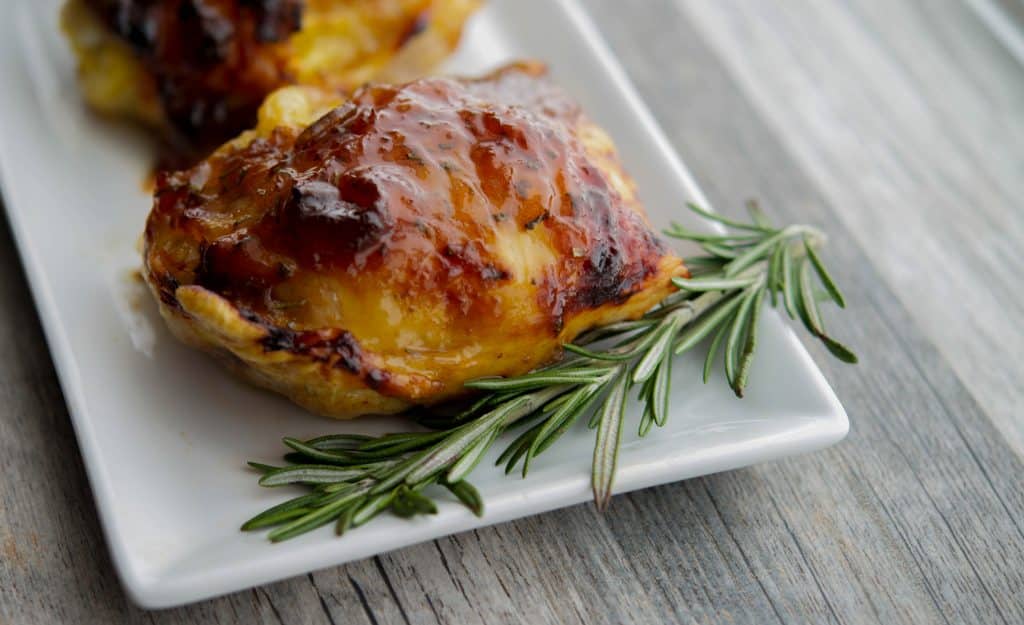 Balsamic Apricot Chicken Thighs with a sprig of rosemary.