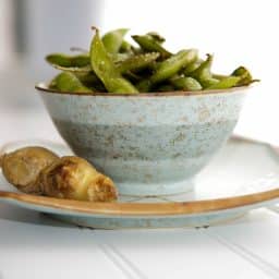 A bowl of edamame with ginger.