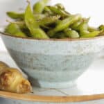 Edamame tossed with soy sauce, fresh ginger, sesame oil and Kosher salt; then roasted makes a healthy flavorful snack. 