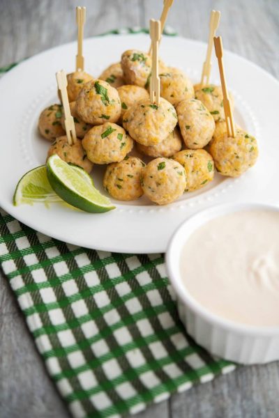 Sriracha and Lime Turkey Meatballs with Dipping Sauce on a plate with toothpicks.