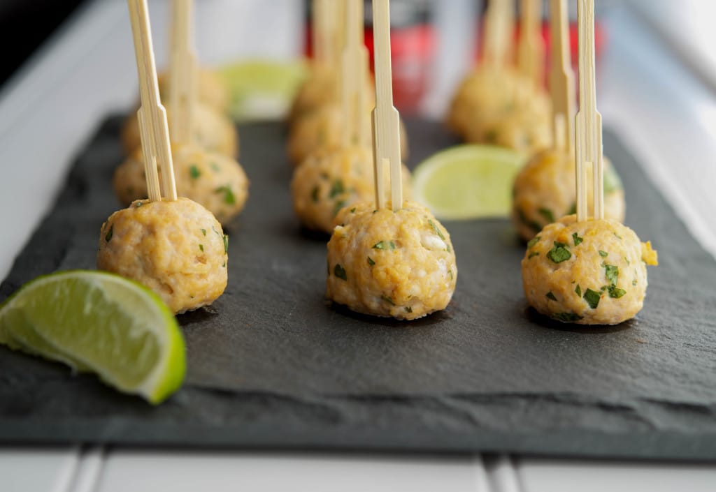 Sriracha and Lime Turkey Meatballs with toothpicks on a slate platter. 