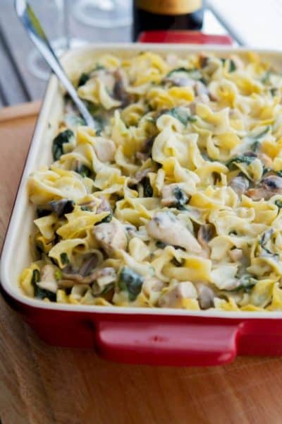 Creamy Chicken, spinach and mushroom casserole in a red casserole dish