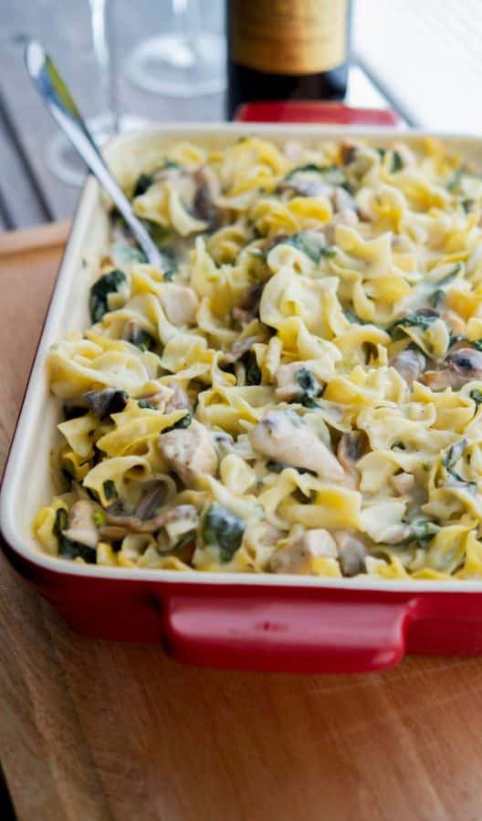 Creamy Chicken, Spinach & Mushroom Casserole in a red casserole dish.