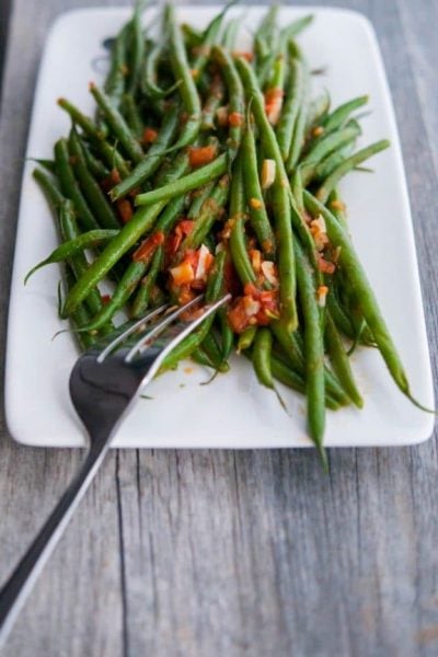 Green beans sautéed with fresh garlic and tomatoes in a light broth make the perfect accompaniment to any meal.