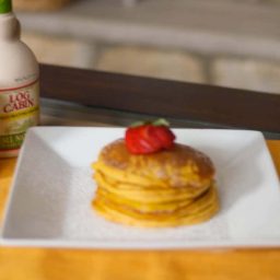 Pumpkin Pancakes on a plate topped with strawberries.