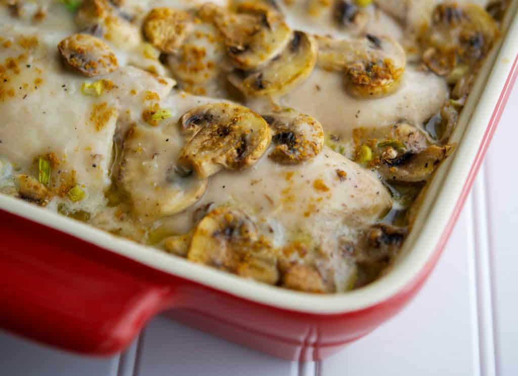 A close up of chicken parisienne in a red baking dish. 