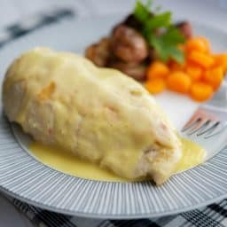Chicken on a plate topped with bernaise sauce.