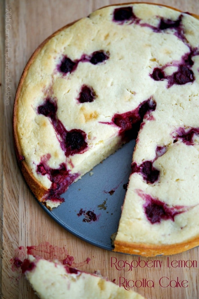 Raspberry Lemon Ricotta Cake with a slice cut out of it. 