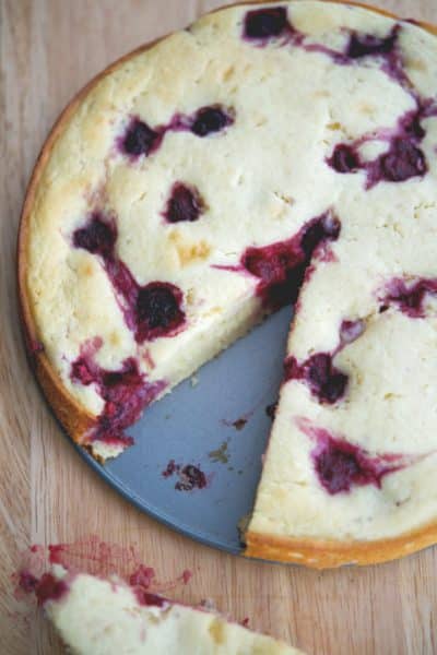 Raspberry Lemon Ricotta Cake on a wooden cutting board.