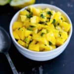 Mango Salsa in a white bowl on a dark background