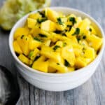 Mango Salsa in a white bowl on a wooden background