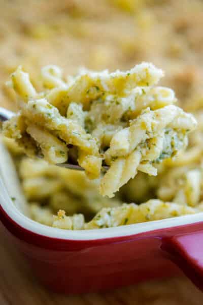 A close up of pesto macaroni and cheese on a spoon
