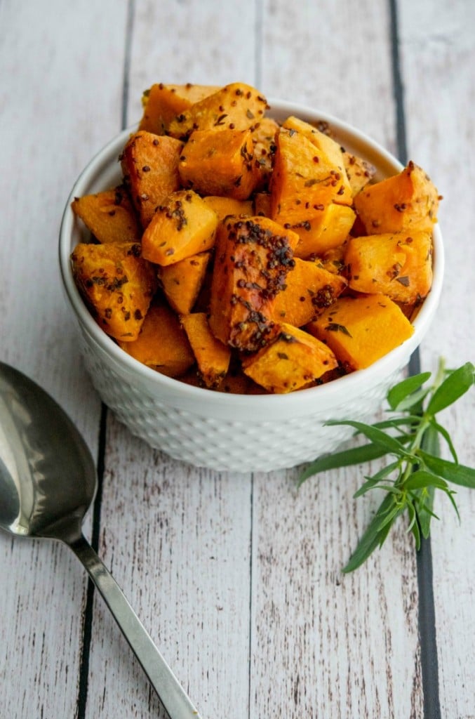 Mustard & Tarragon Roasted Sweet Potatoes in a white bowl. 