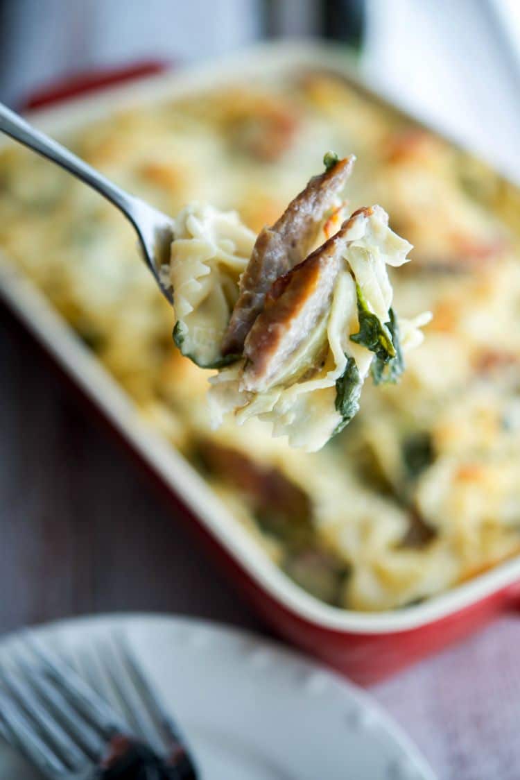 A close up of sausage and pasta on a fork. 