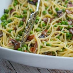 A close up of Spaghetti Carbonara in a white pasta bowl.