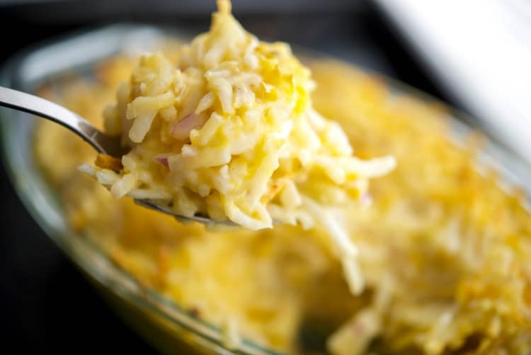 A close up hash brown casserole on a fork. 