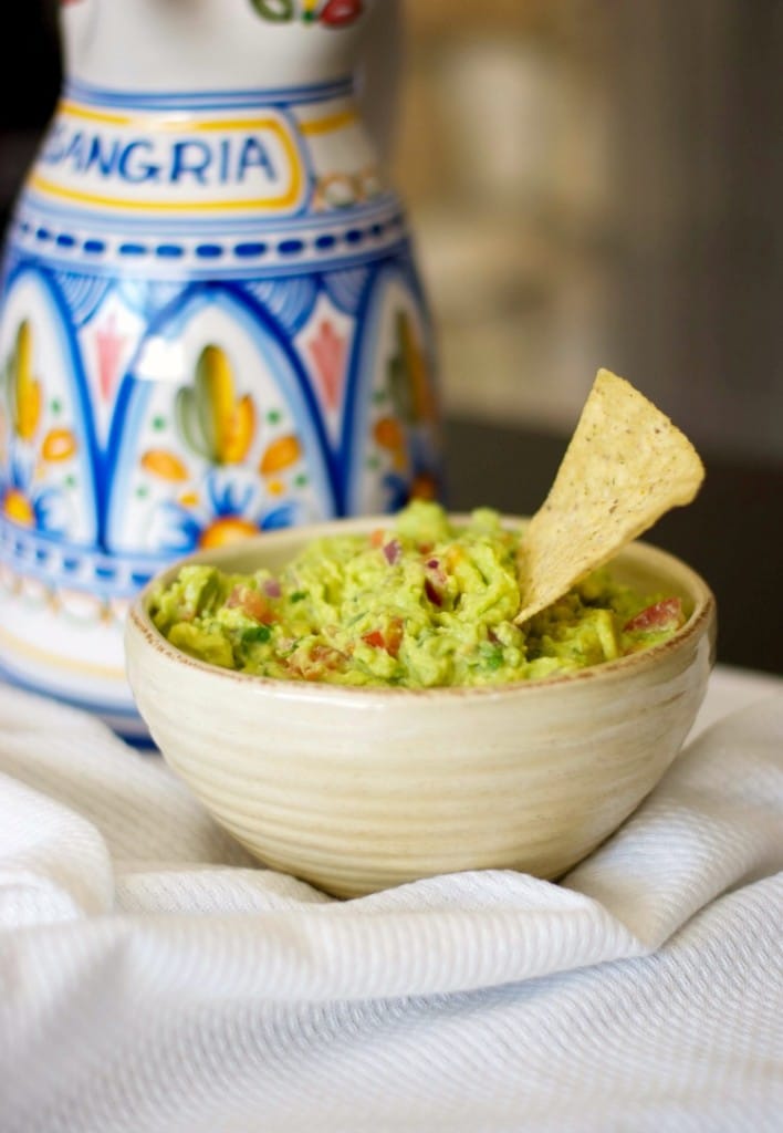 A bowl of food on a table, with Guacamole and Avocado