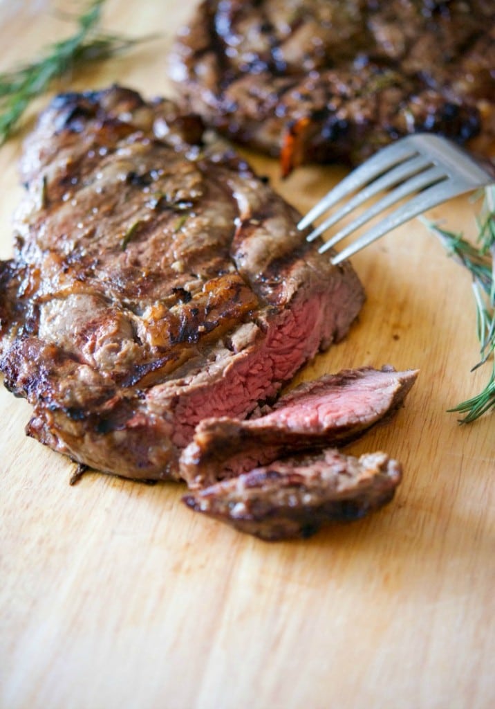 A close up of Tuscan rib eye steak with a few slices cut.