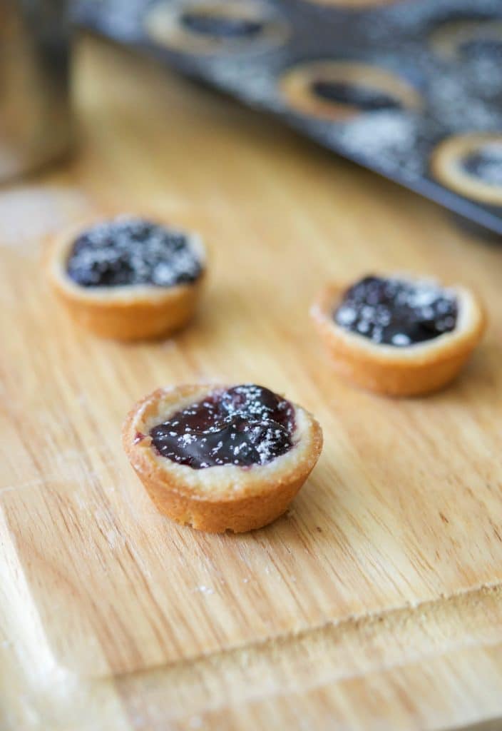 Blueberry Pie Tassies on a wooden cutting board