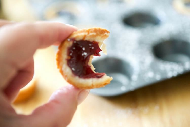 Blueberry Pie Tassies being held between fingers