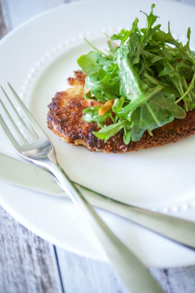 Honey Mustard Chicken Cutlets with Arugula Salad on a white plate. 