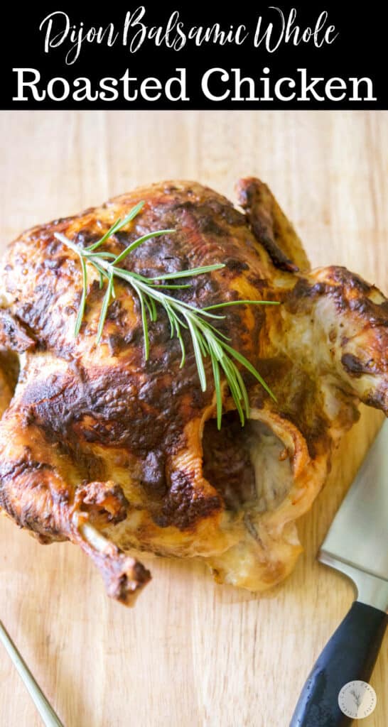 A closeup of Dijon Balsamic Whole Roasted Chicken on a wooden cutting board. 