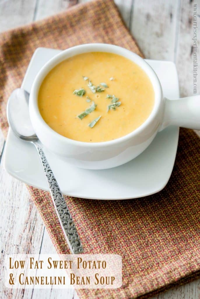 A bowl of soup and a spoon on a table, with Potato and Bean