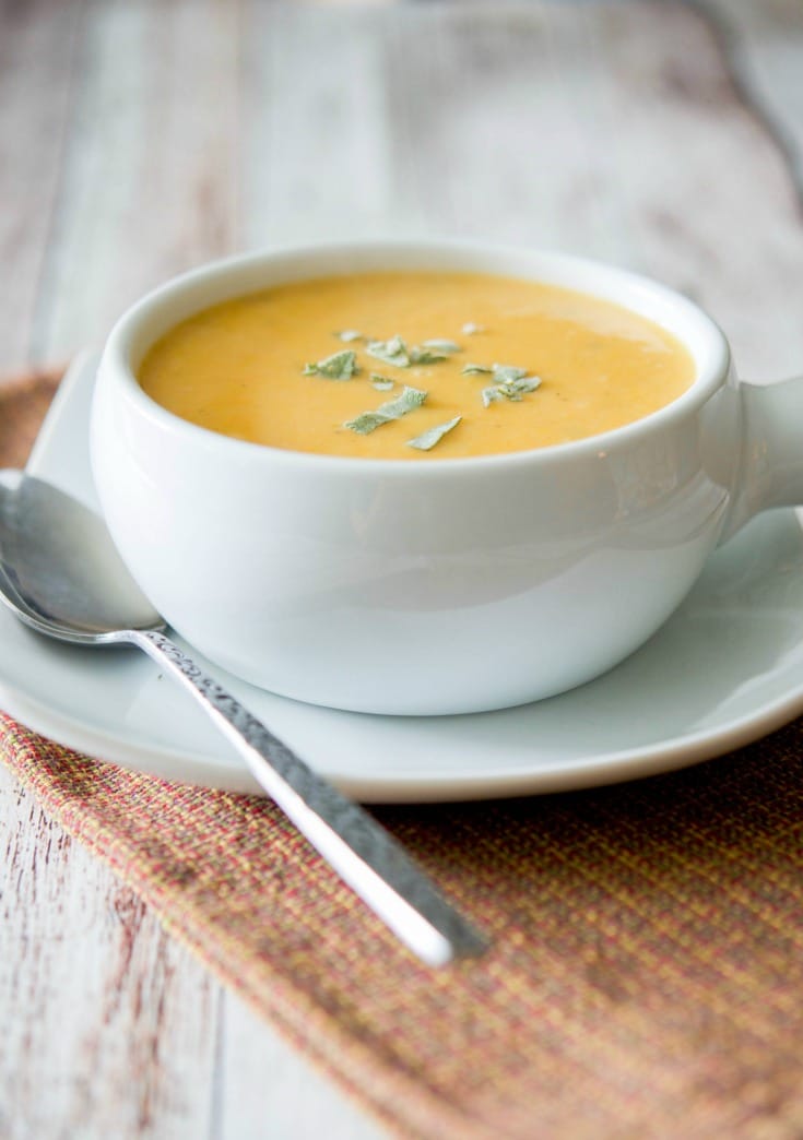 Sweet Potato and Cannellini Bean Soup in a soup crock with spoon.