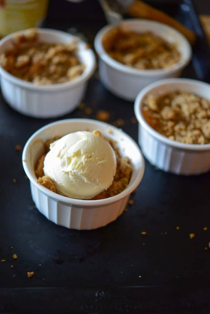 Fireball Apple Crumble in a dish with ice cream on top. 