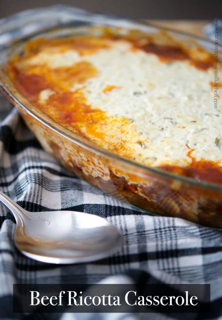 A close up of Beef Ricotta Casserole in a glass dish with a spoon.