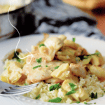 Chicken on a white plate with artichokes and mushrooms