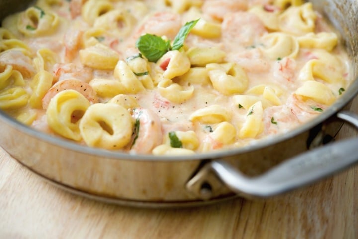 A bowl filled with pasta and cheese, with Shrimp and Tortellini