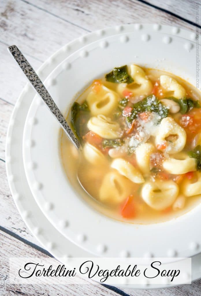 A bowl of soup and a spoon, with Tortellini en brodo