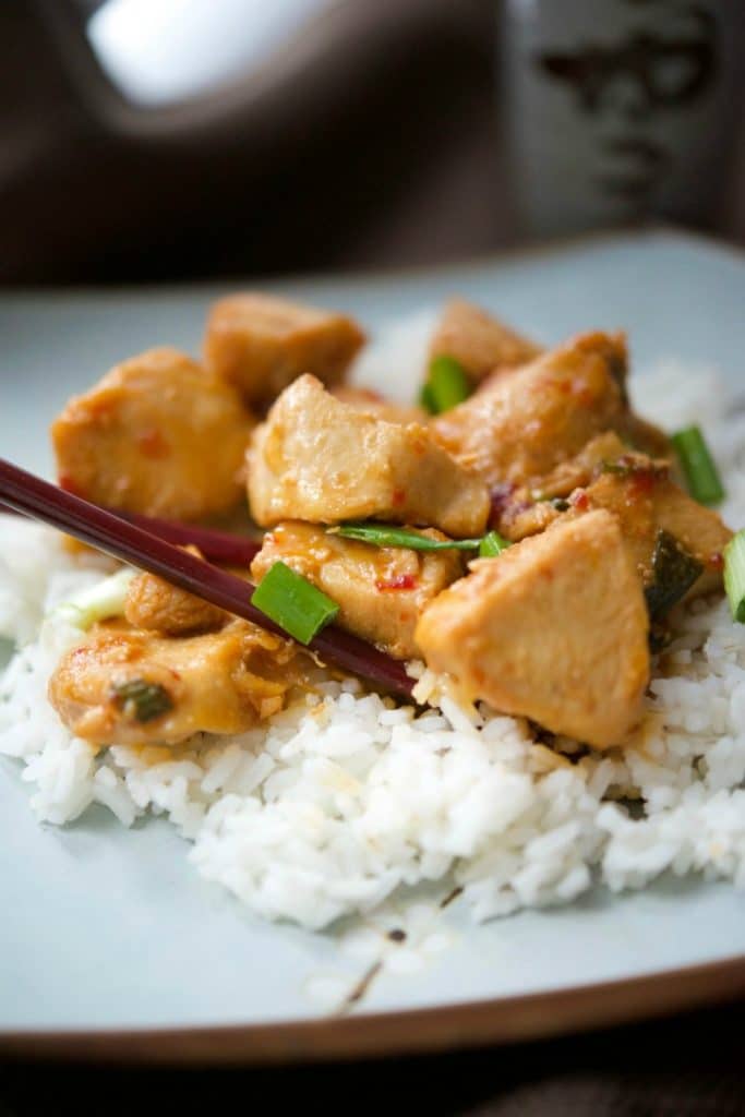 A close up of Asian Chili Garlic Chicken over rice on a plate. 