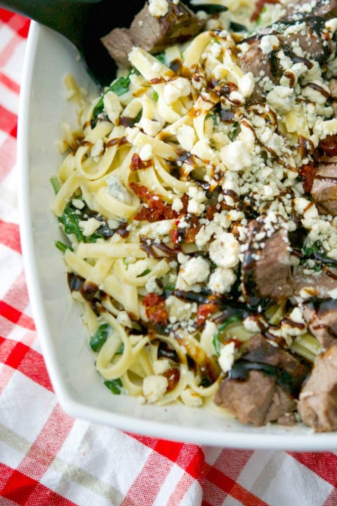 Grilled steak over fettuccine alfredo tossed with fresh spinach and Gorgonzola cheese; then topped with sun dried tomatoes and balsamic drizzle.