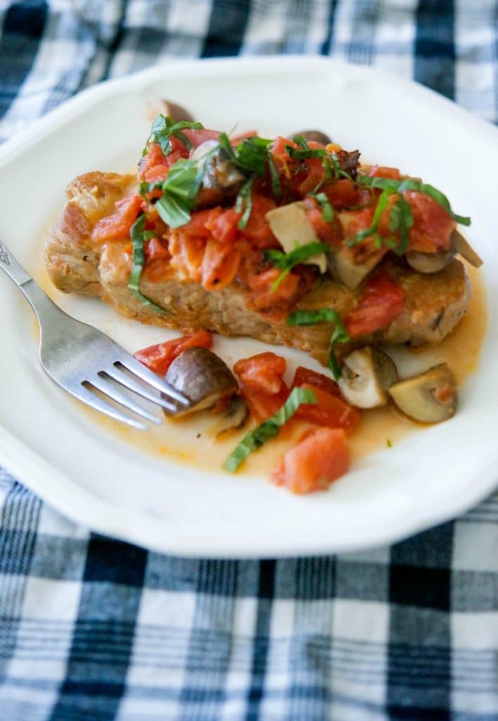 Braised boneless center cut pork chops with fire roasted tomatoes and Portobello mushrooms in a light cream sauce is deliciously light and flavorful.