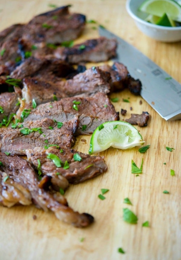 Rib eye steak sliced on a wooden cutting board. 