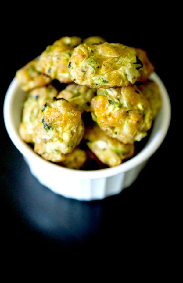 A closeup of a bowl of baked zucchini tots