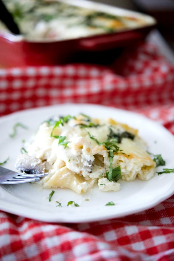 A plate of food roasted vegetable ratatouille lasagna with a fork