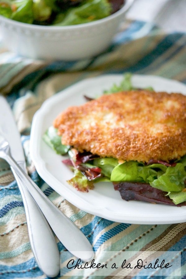 Chicken a la Diable: Boneless breaded chicken cutlets coated in a cajun seasoning breadcrumb mixture then fried and placed on top of mixed greens. 