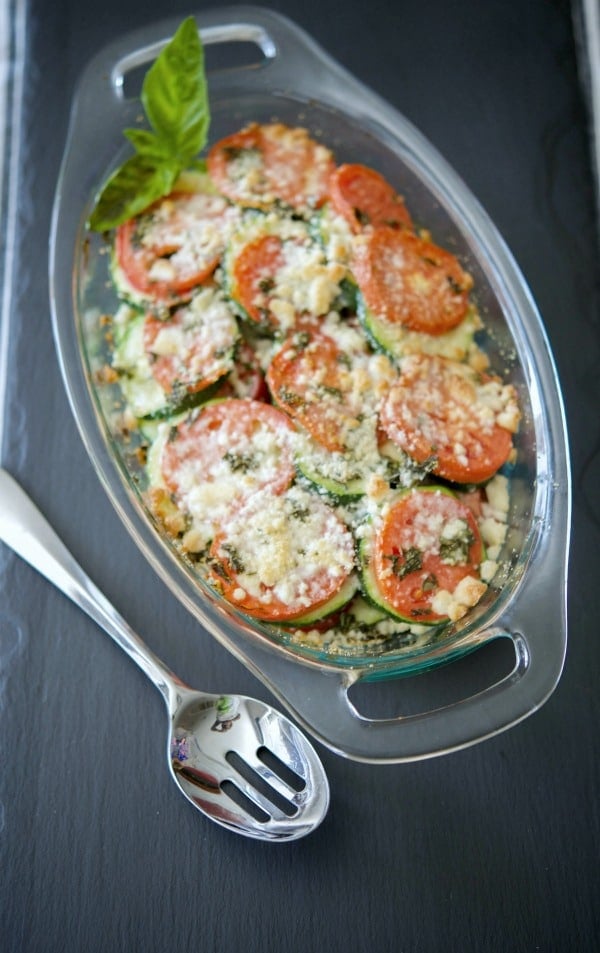 A dish of tomato and zucchini gratin with a spoon