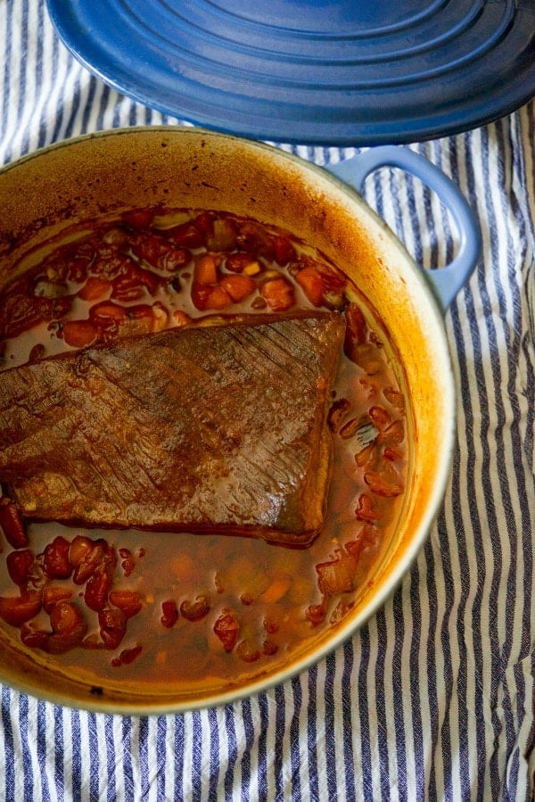 Beef brisket with tomatoes, garlic, carrots, brown sugar and cinnamon whiskey in a dutch oven. 