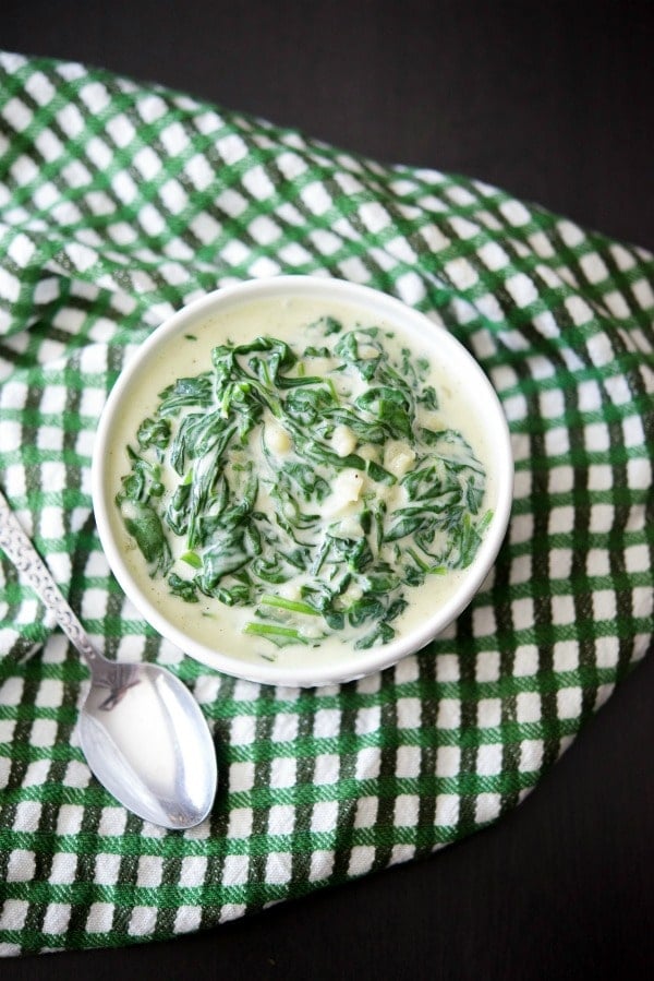 A close up of Creamed Spinach in a white bowl. 