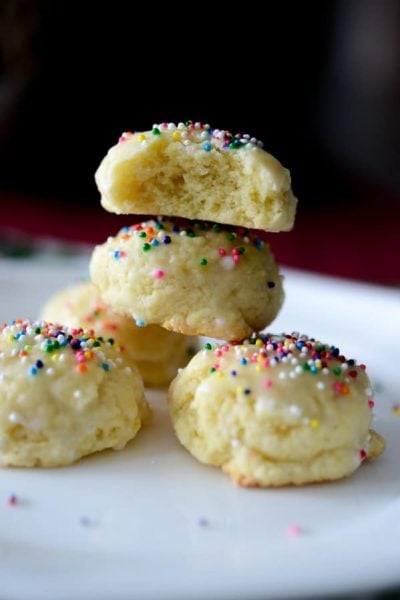 Italian Anise Cookies traditionally are a soft, licorice flavored cookie covered with a powdered sugar glaze and nonpareil's sprinkled on top.  #cookies #italian #anise