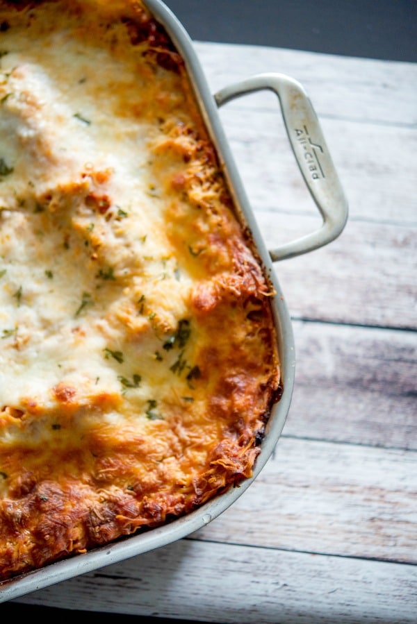 Lasagna in a roasting pant on top of a wooden table