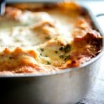 A close up of a slice of lasagna in a pan