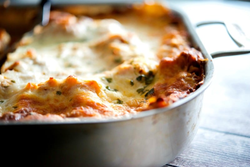 A close up of a slice of lasagna in a pan